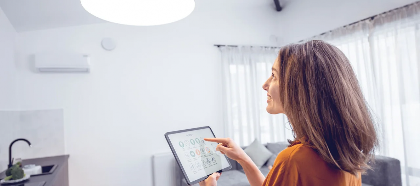 Mulher ajustando iluminação via tablet, mostrando com o smart living integra tecnologia ao estilo de moradia inteligente